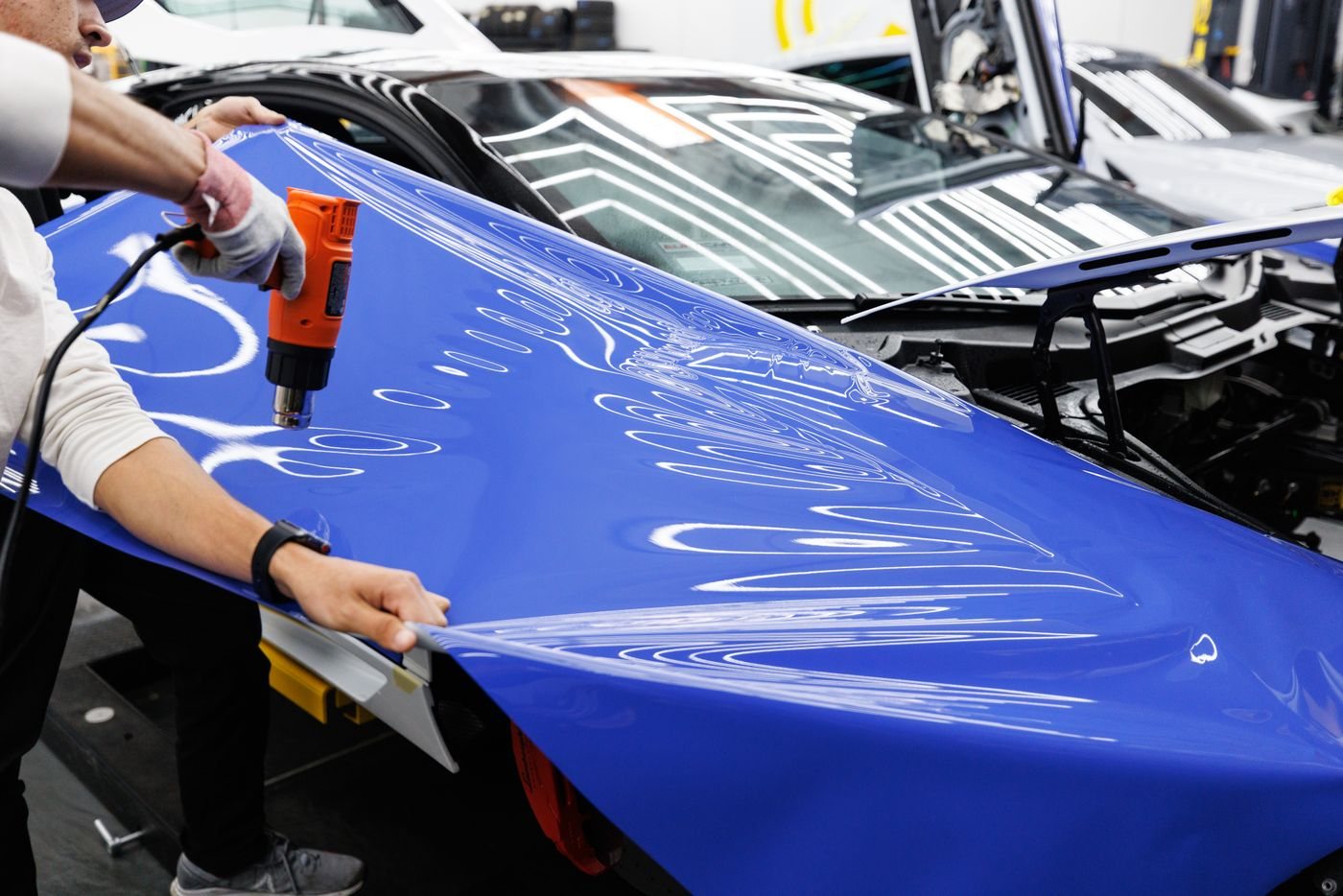 **A colour change going on.** Gloss blue over the original paint. The paint underneath is untouched, which is the whole point of vinyl over a respray.