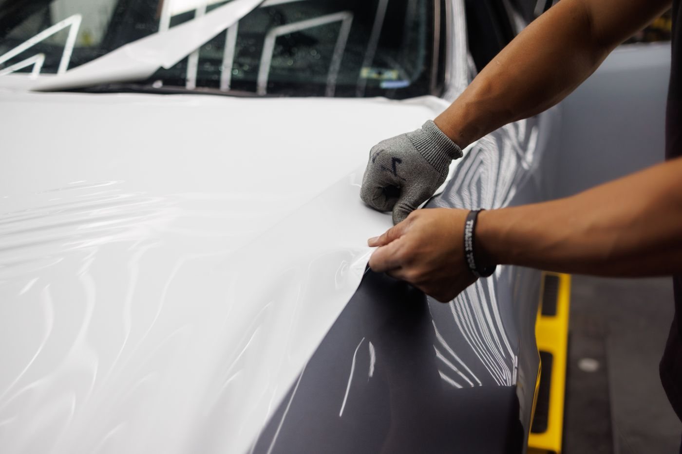 **Edges last.** Every seam and return gets tucked and inspected under the light before a car leaves the bay, because edges are where a bad wrap shows first.